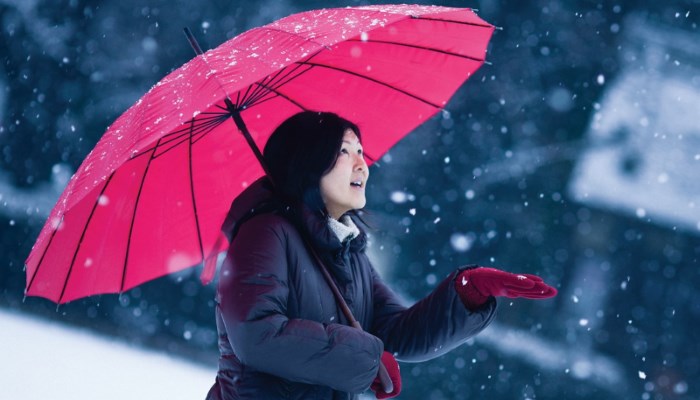 in the snow with red umbrella