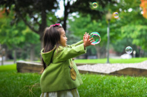 child playing with bubbles