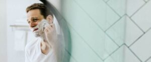 man shaving in mirror