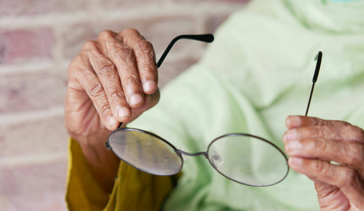 holding onto pair of glasses